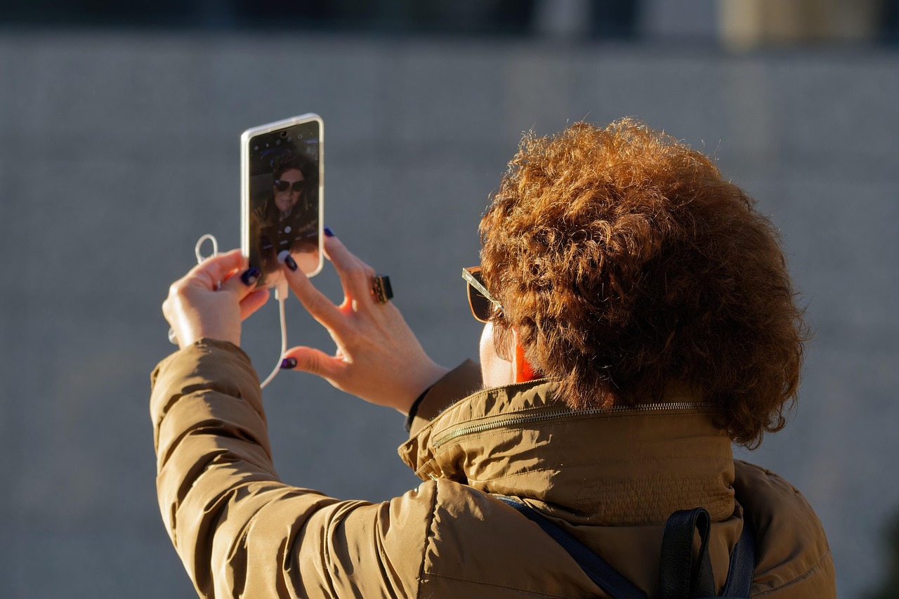 Woman holding up a phone to take a picture or video, symbolizing high-stakes communication and AI assistance.
